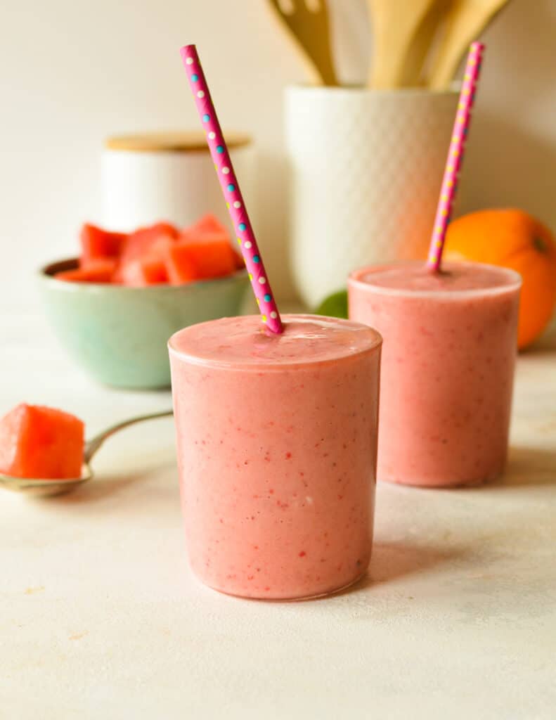 two watermelon smoothies with straws.