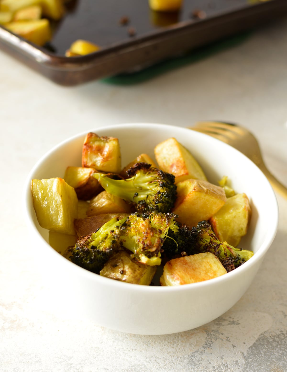a bowl of roasted potatoes and broccoli.