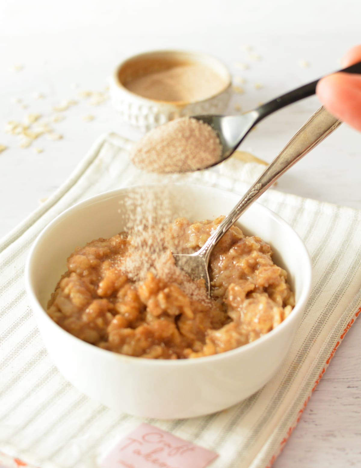 sprinkling cinnamon sugar on oatmeal.