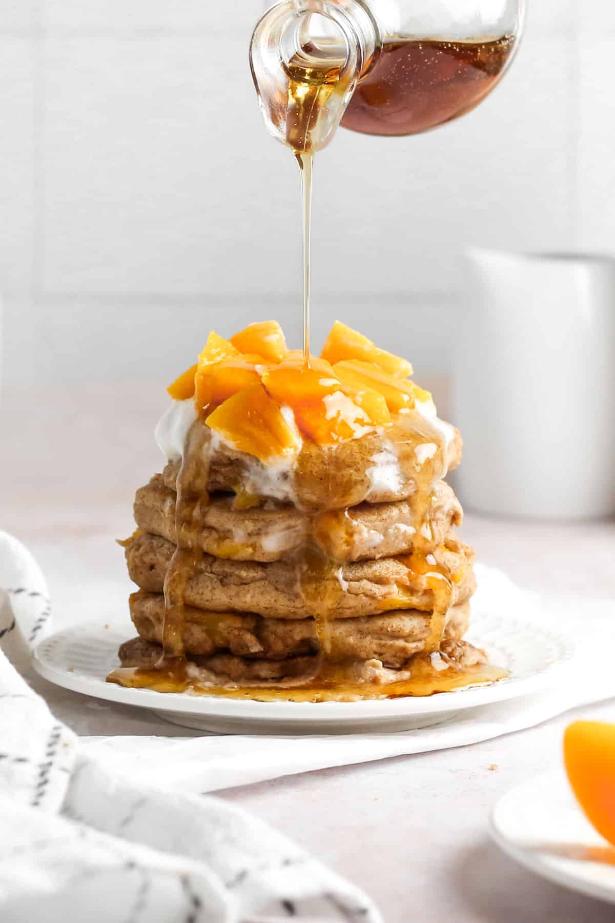 pancakes with peaches and syrup.