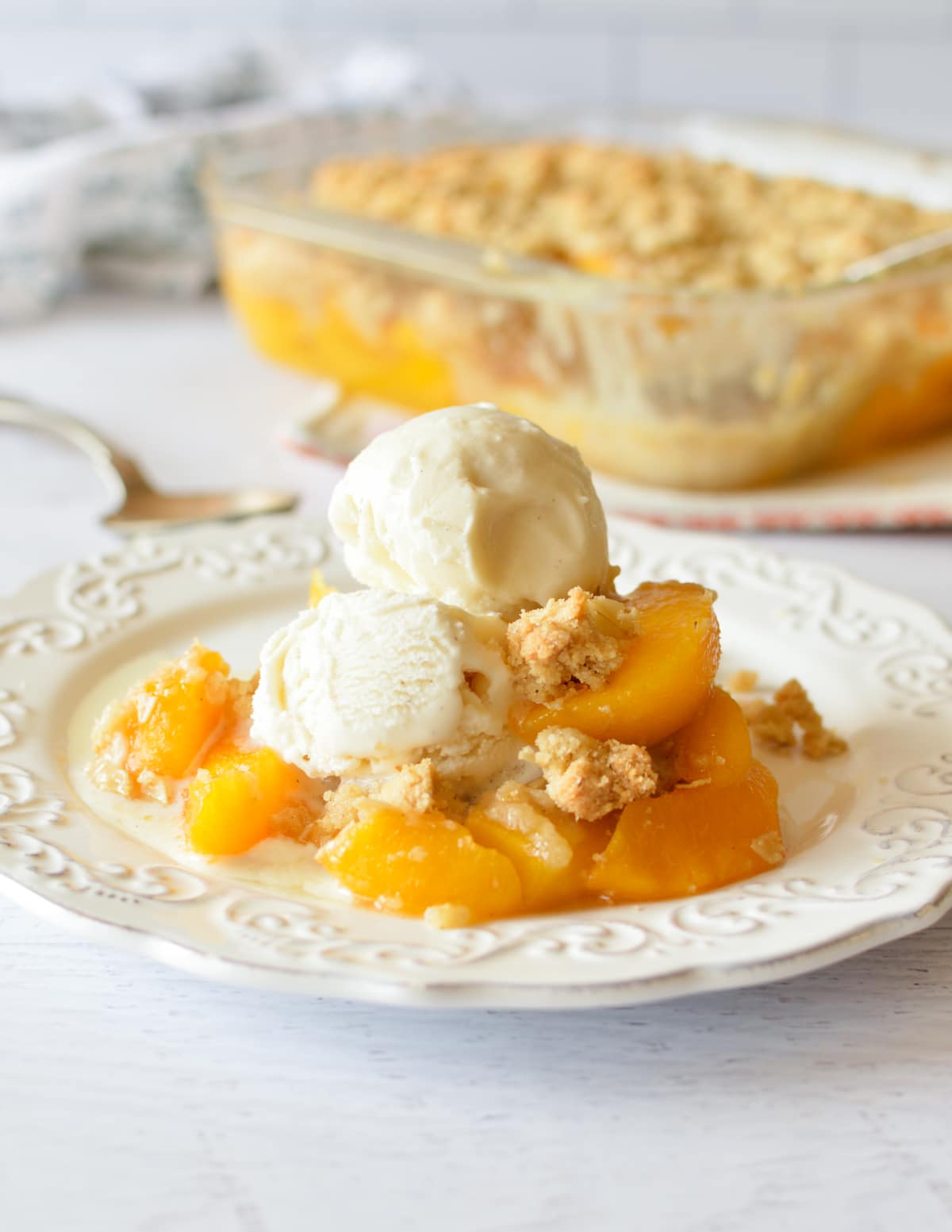 a peach crisp with vanilla ice cream on top.