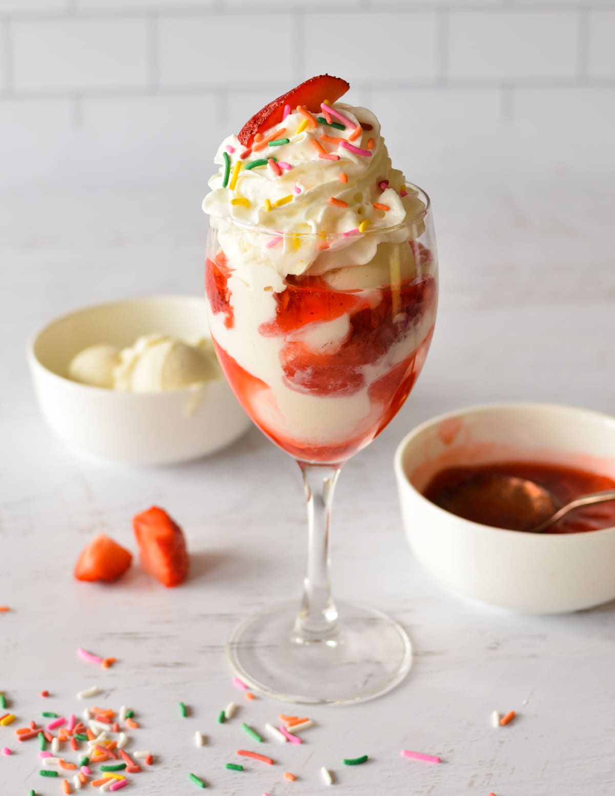 a strawberry sundae with whipped cream and sprinkles.