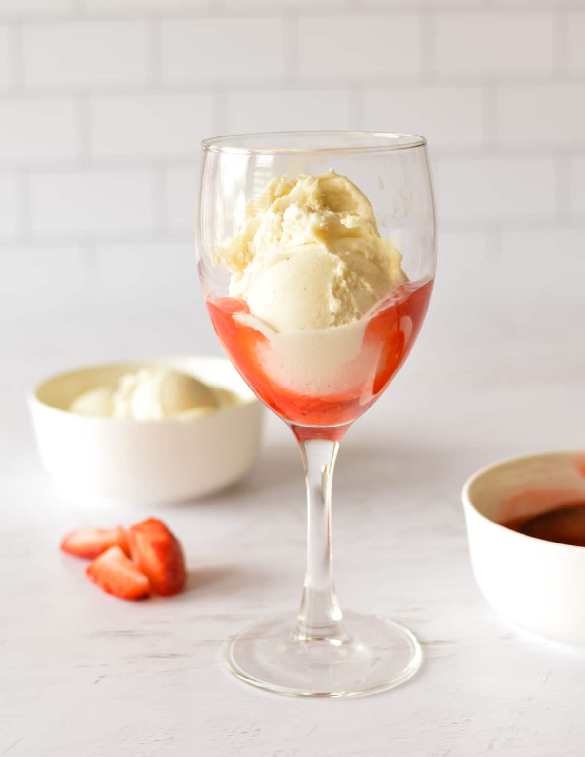 strawberry sauce and ice cream in a glass.