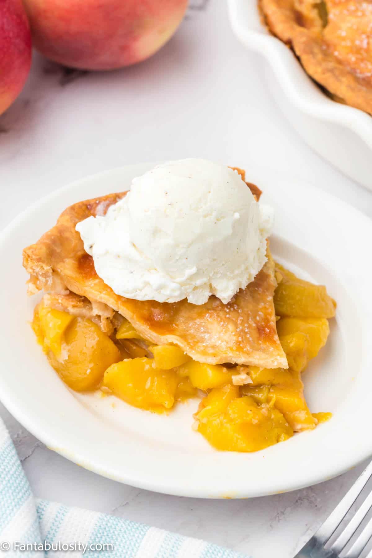 a slice of peach pie with ice cream.