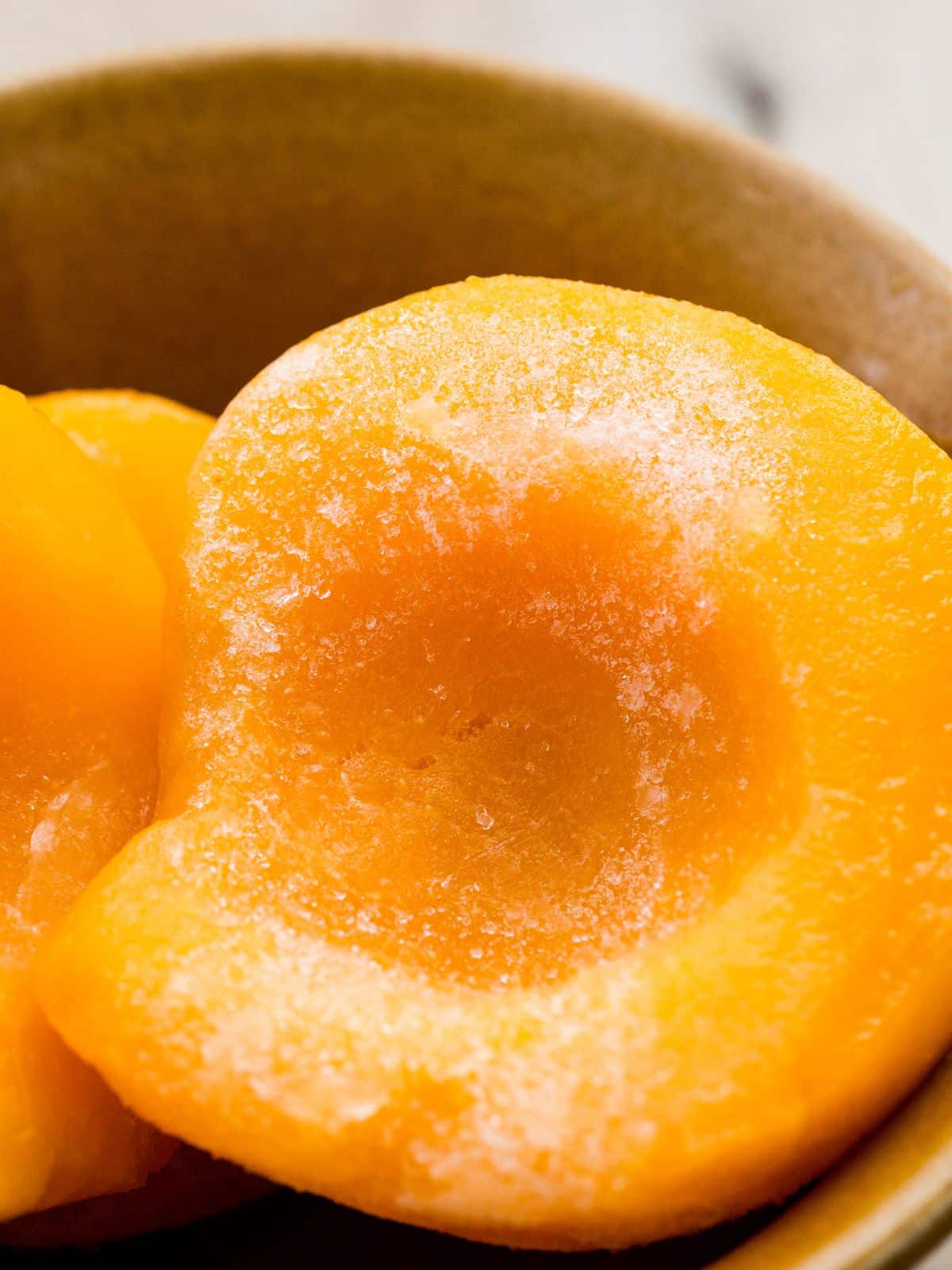 frozen peach halves in a bowl.