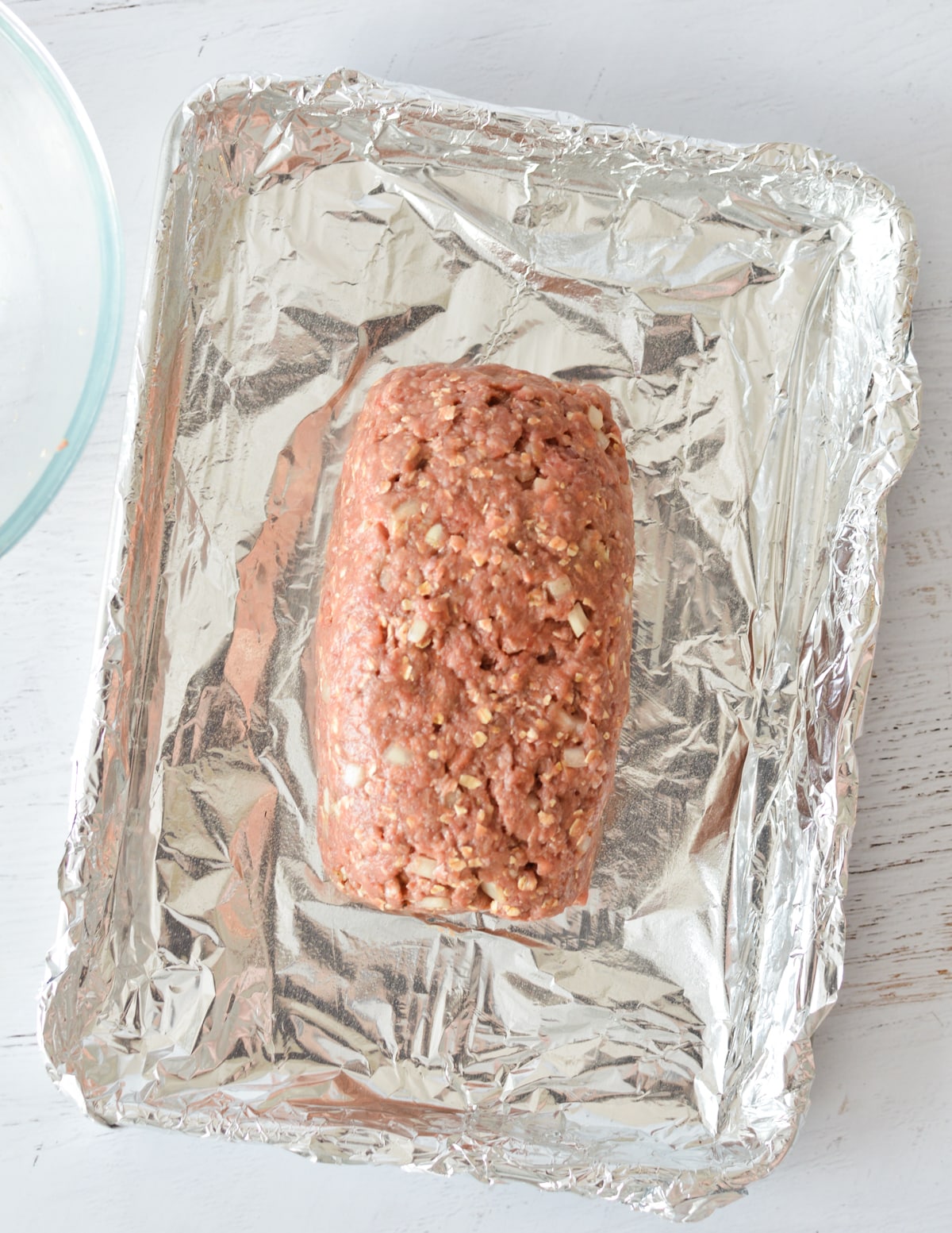 an unbaked meatloaf on a sheet pan.