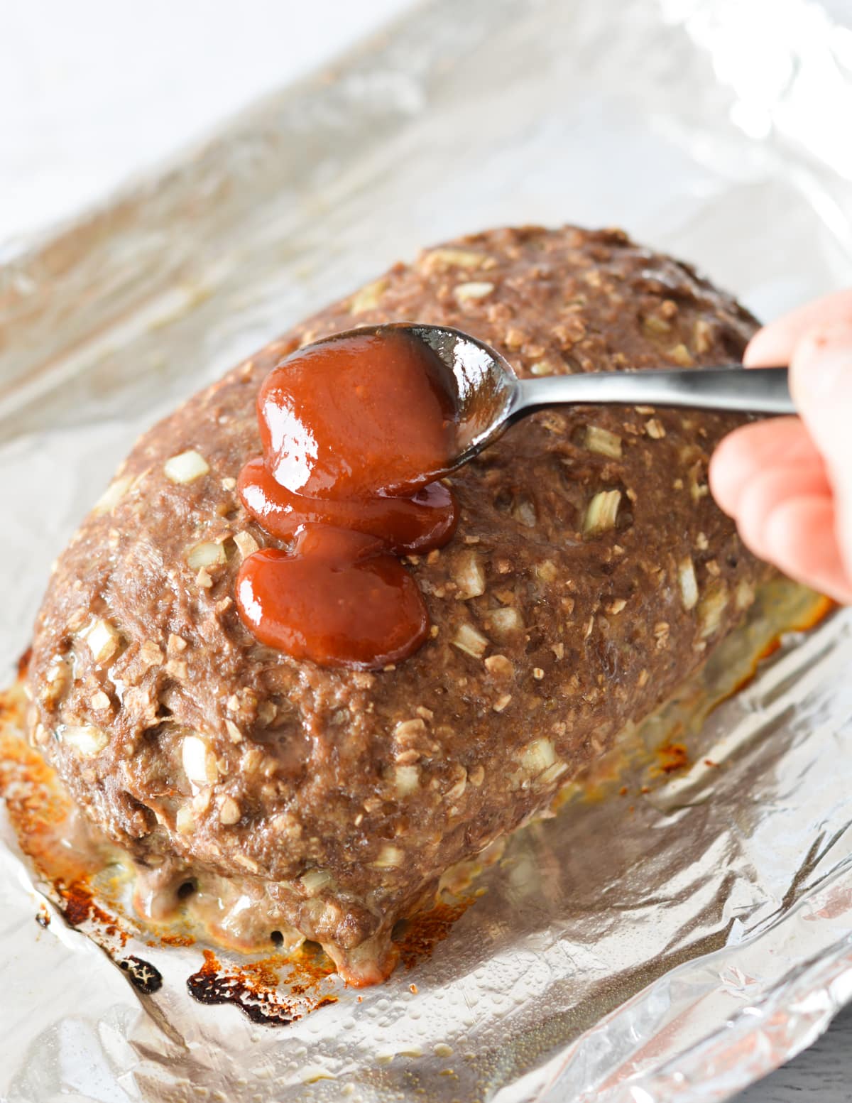 spooning glaze onto a meatloaf.