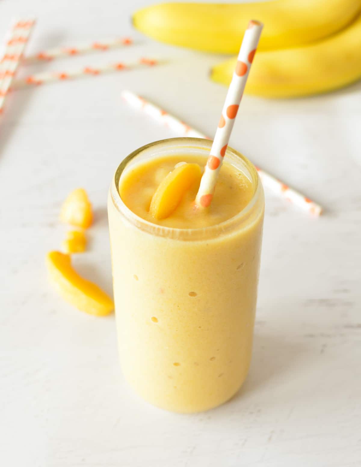 a peach smoothie with a straw.