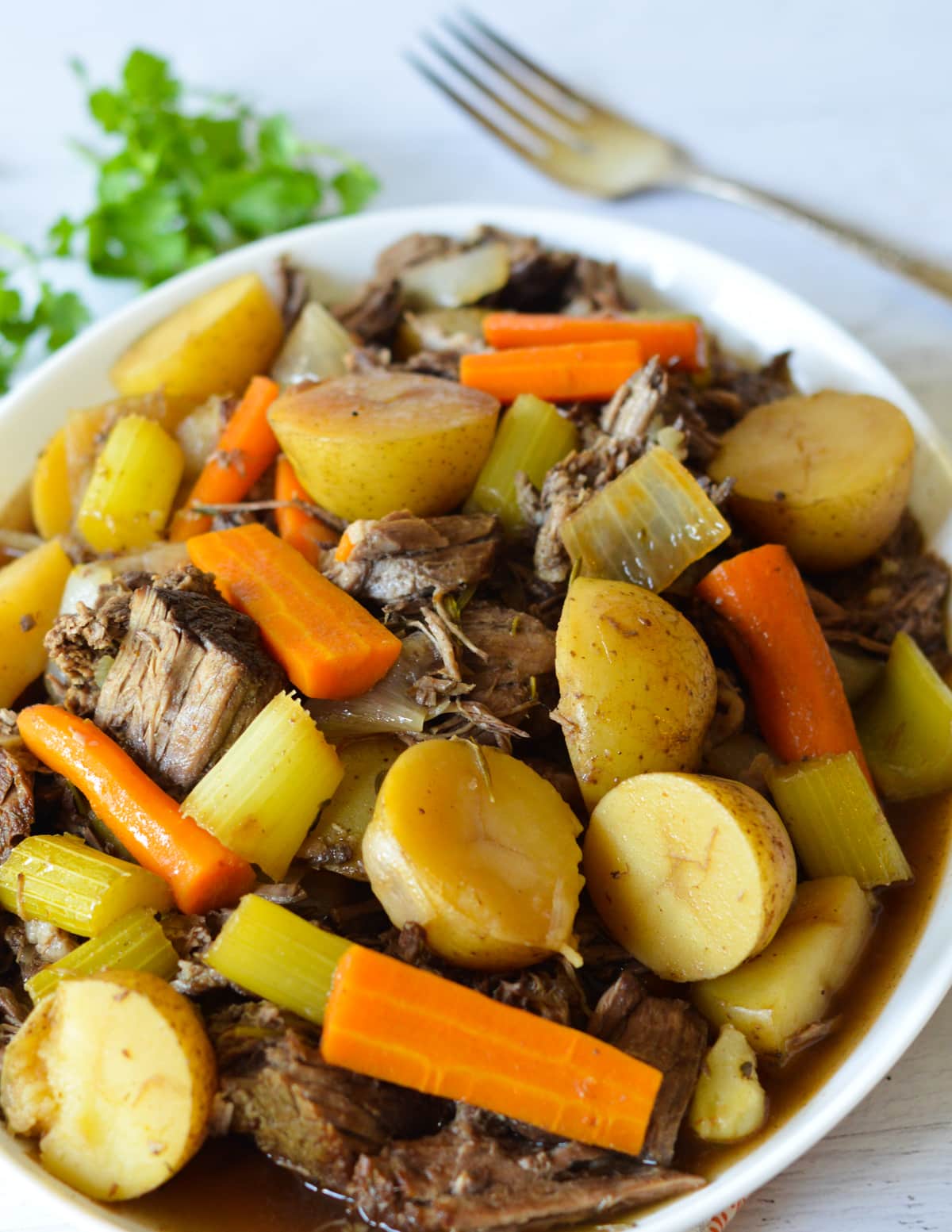 a platter with pot roast, potatoes, and veggies on it.