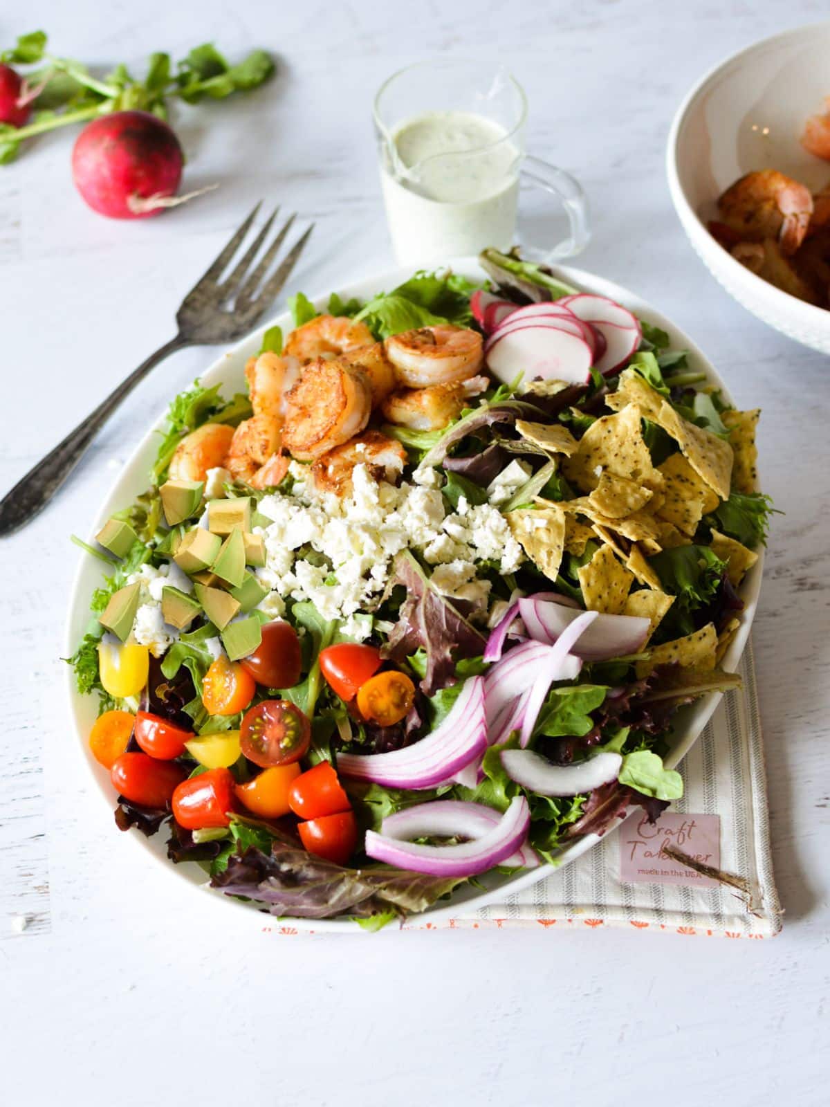 mixed greens with shrimp, avocado, feta, red onion, tomatoes, and chips.