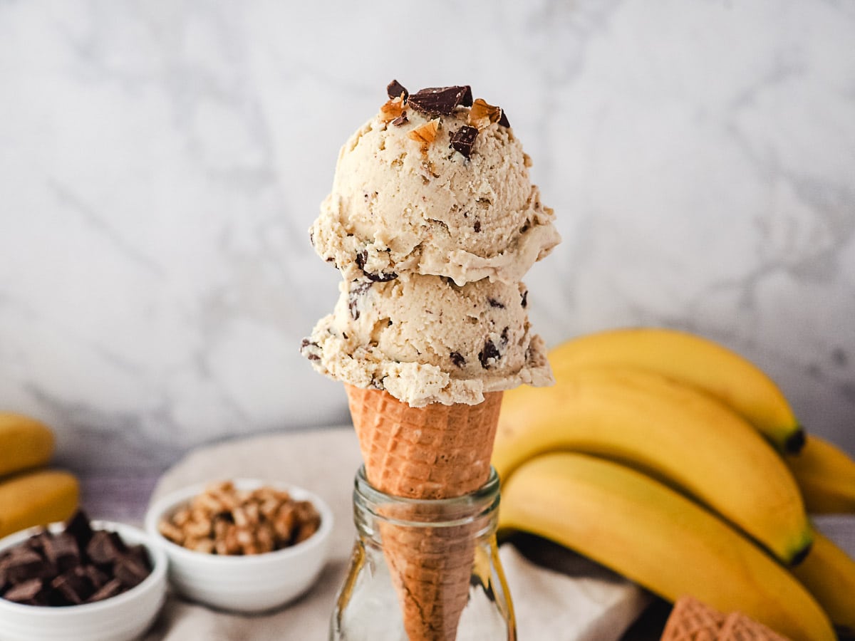 two scoops of chunky monkey ice cream on a cone.