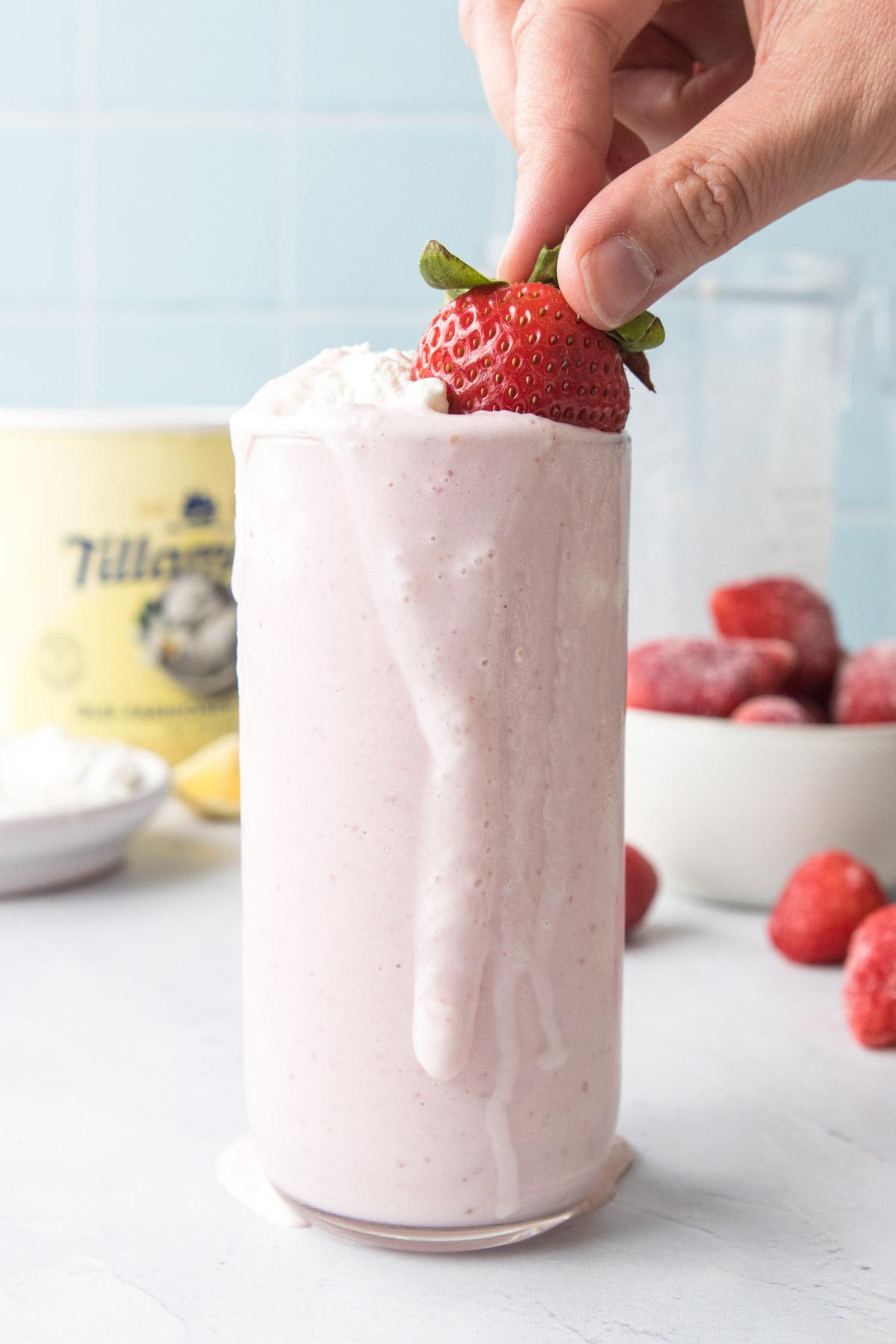 strawberry banana milkshake with whipped cream and strawberry on top.