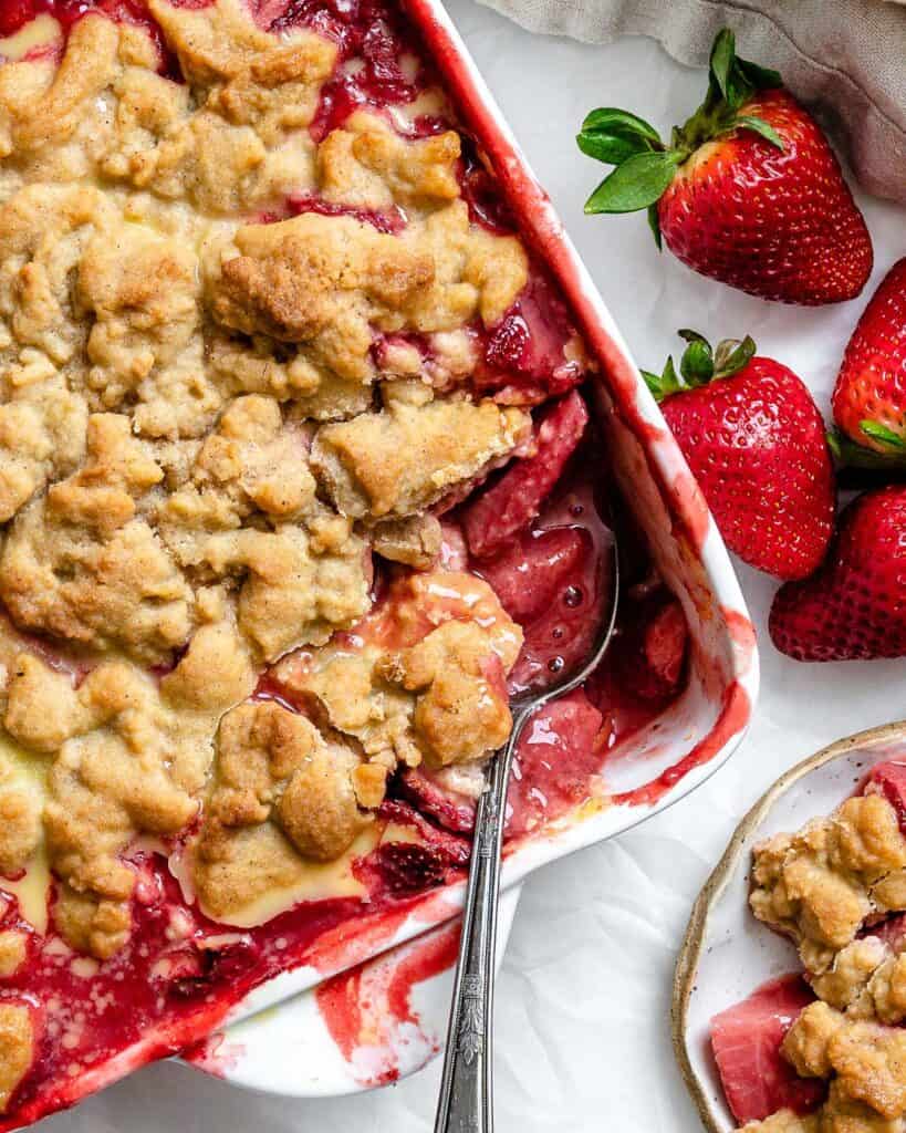 a spoon in a strawberry crumble.