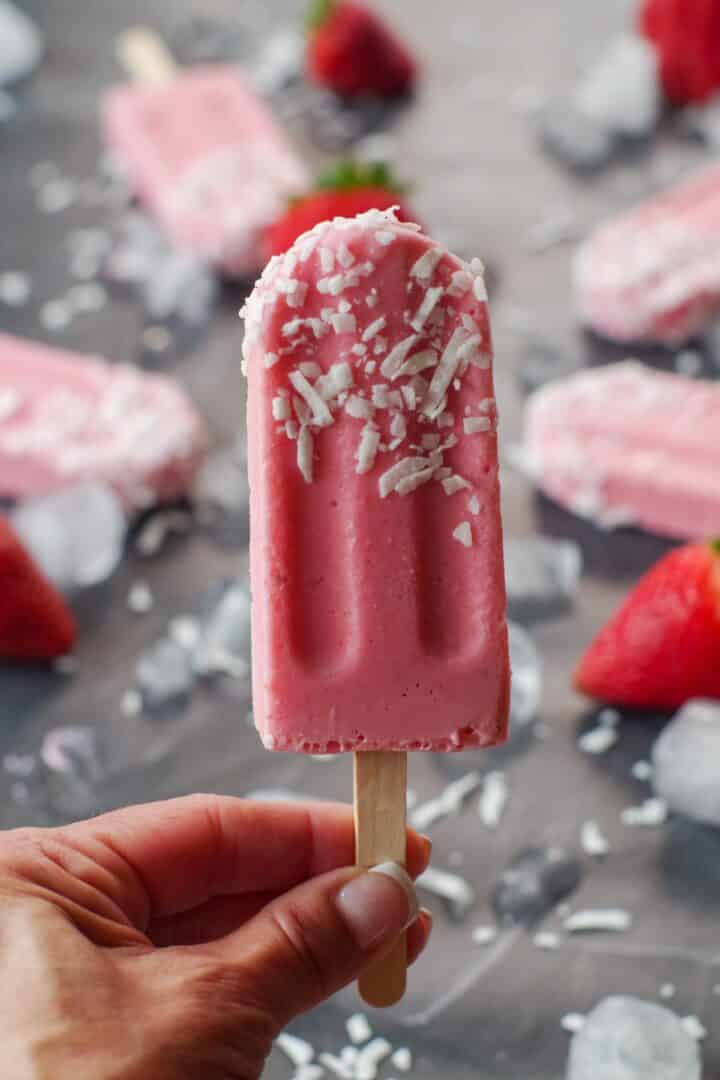 hand holding a strawberry popsicle