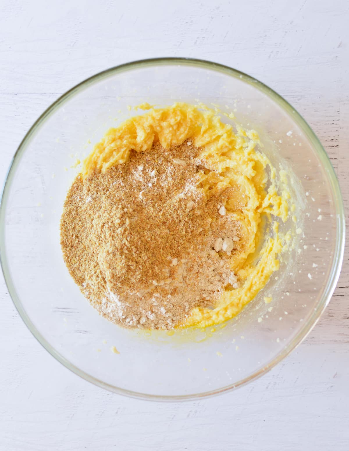 a bowl with creamed butter and sugar with flax meal and oat flour on top.