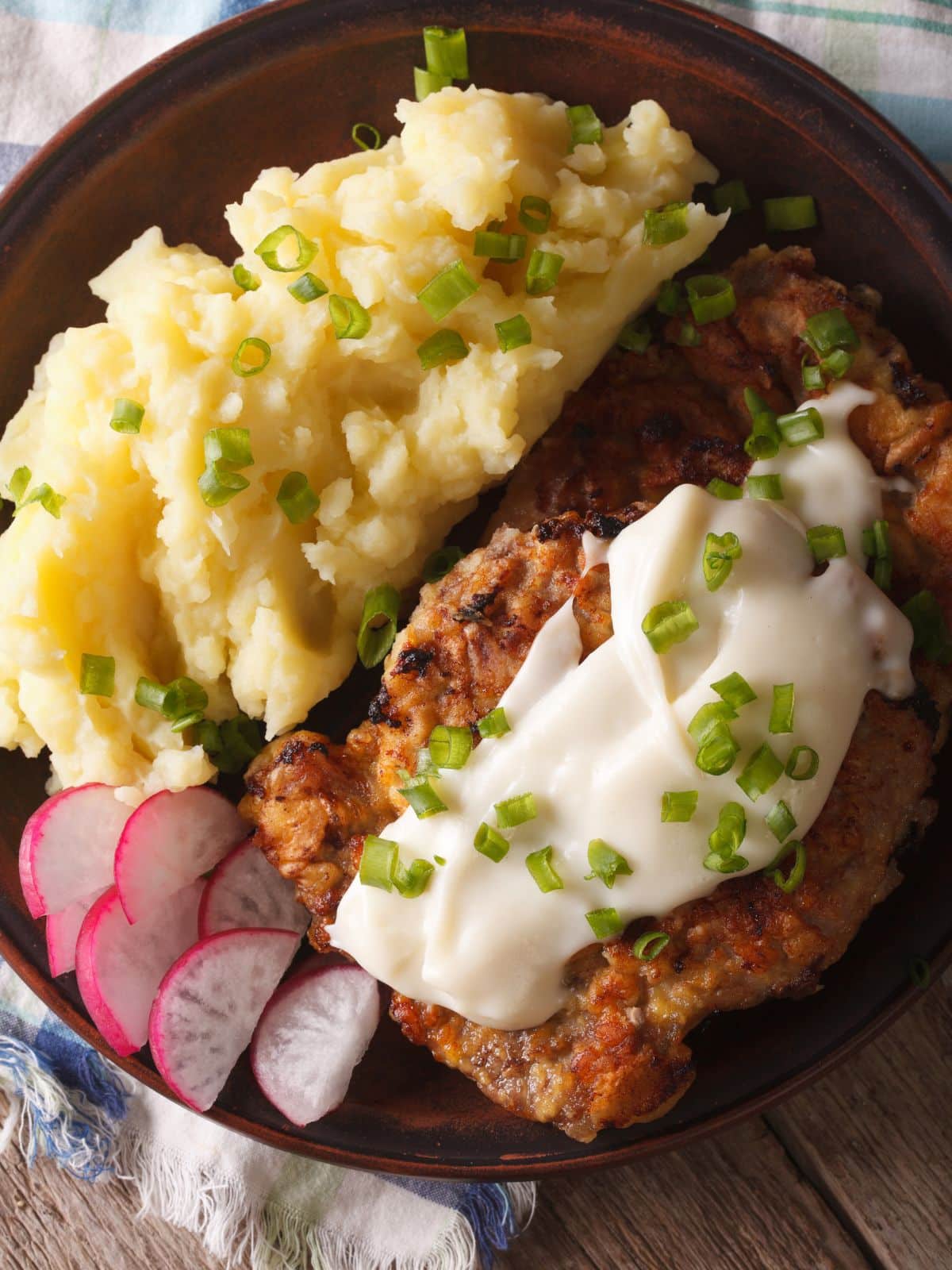 chicken fried steak and mashed potatoes on a plate. 