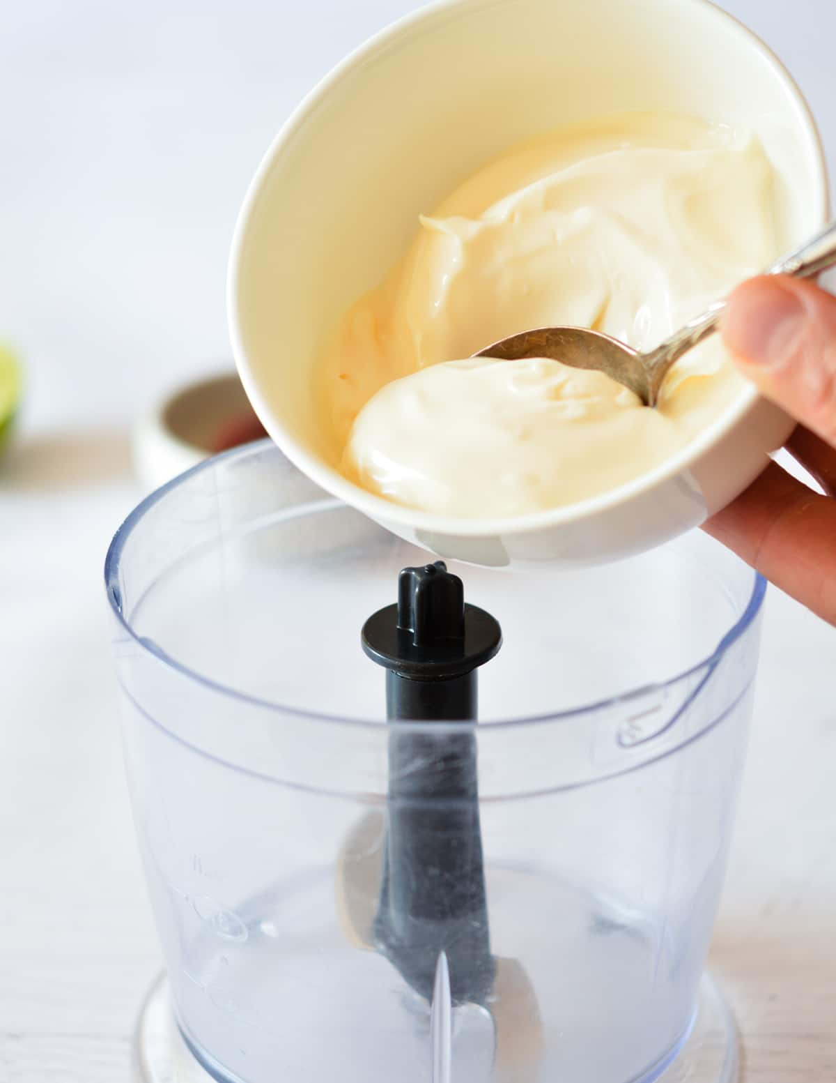 pouring mayo into a small food processor.