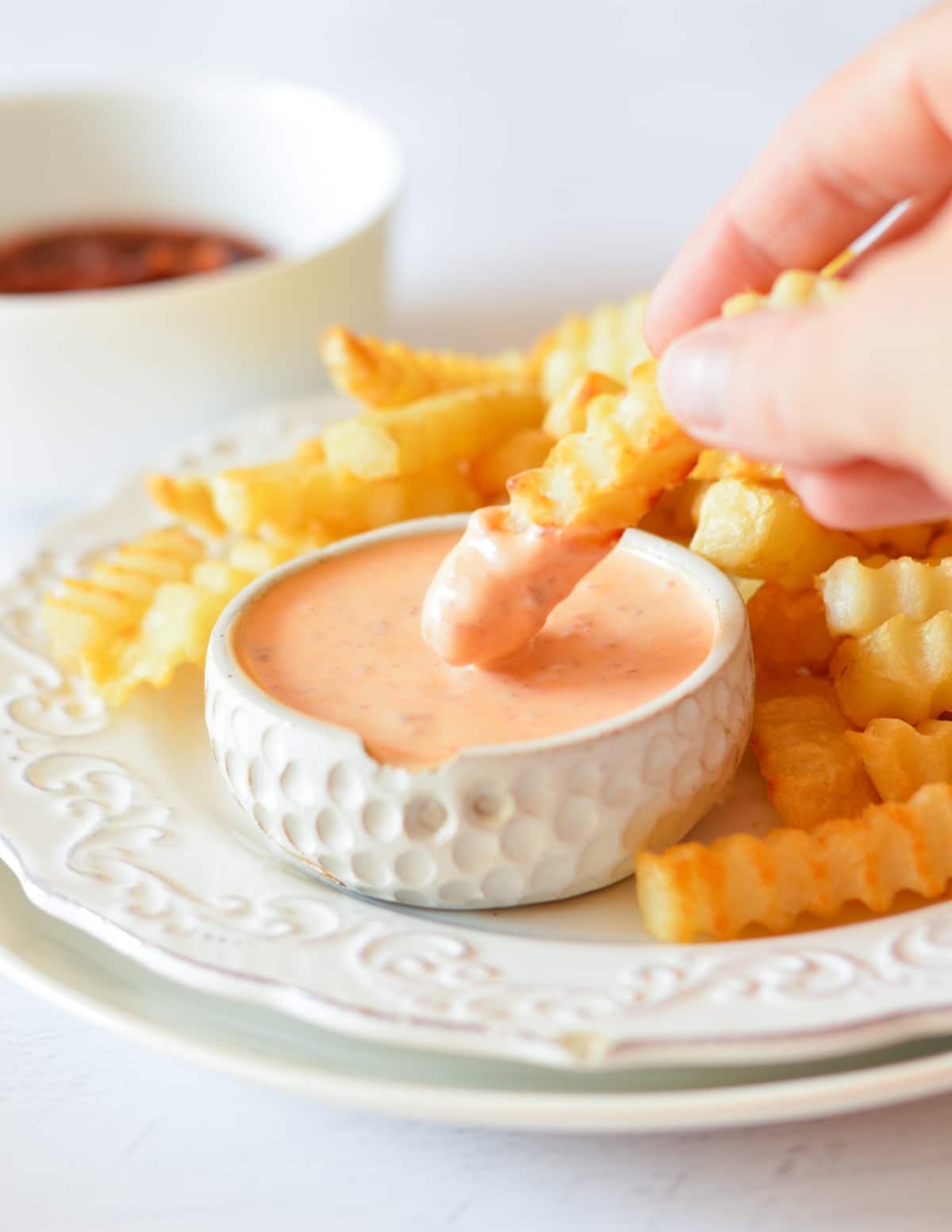 dipping a fry into a bowl of chipotle mayo. 