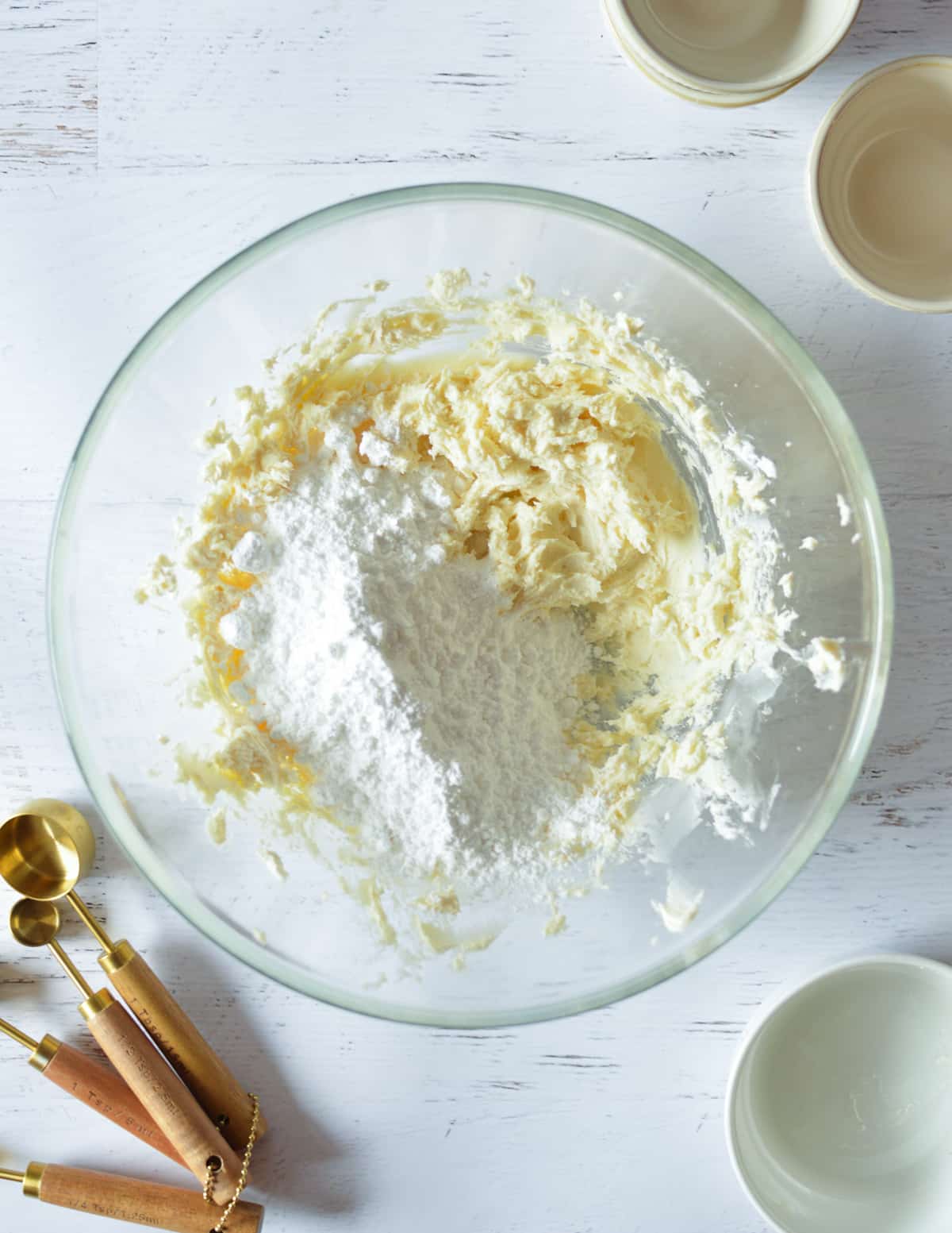 a bowl of whipped cream cheese with powdered sugar on top.