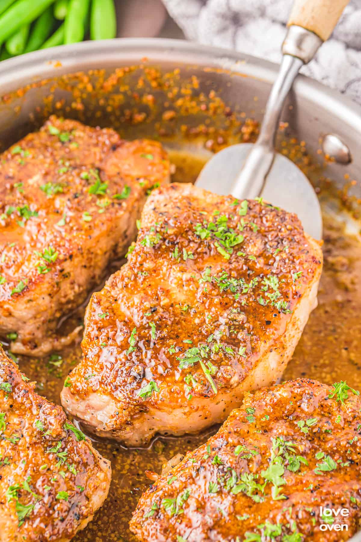 spatula with a pork chop on it in a skillet.