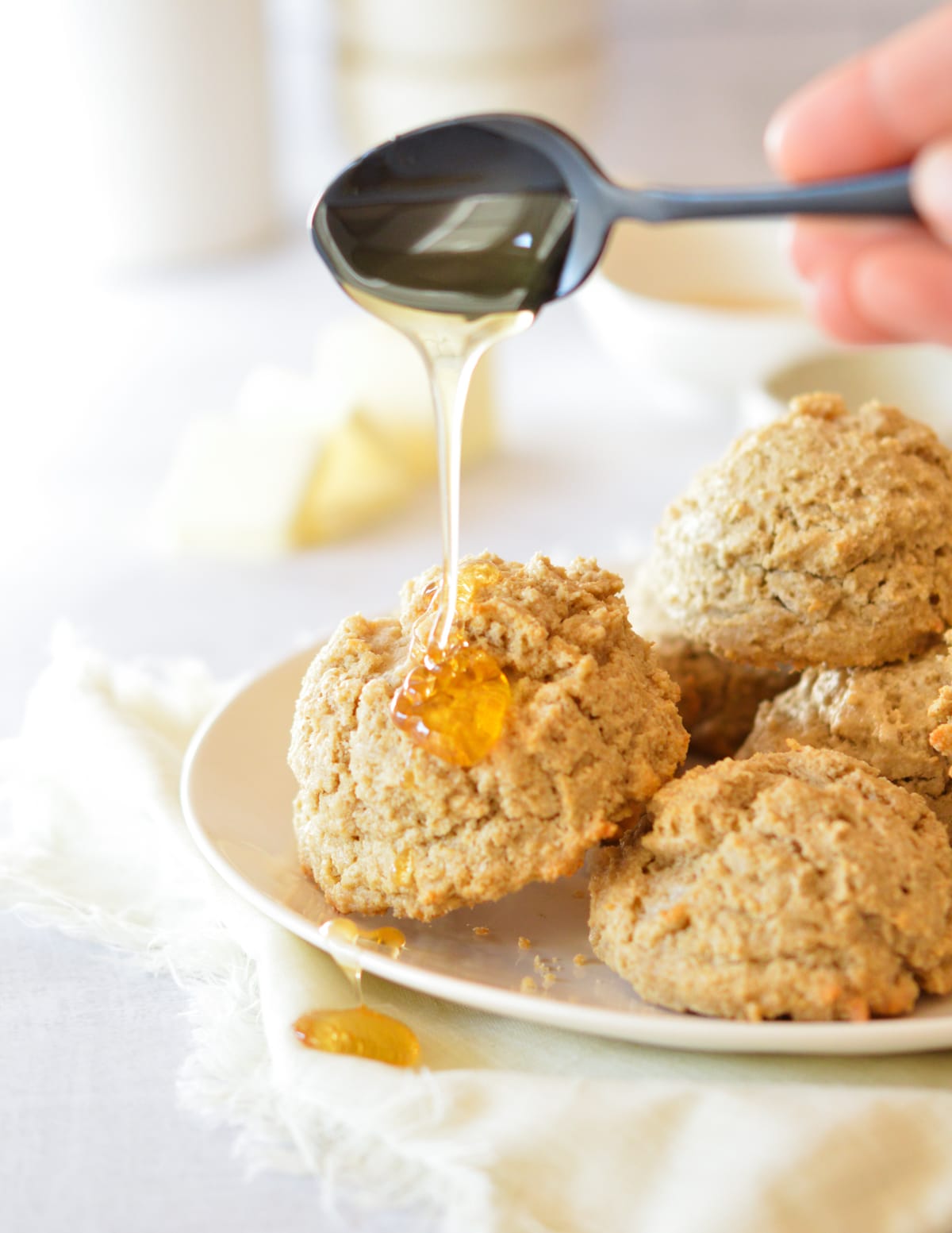 pouring honey onto oat flour biscuits.