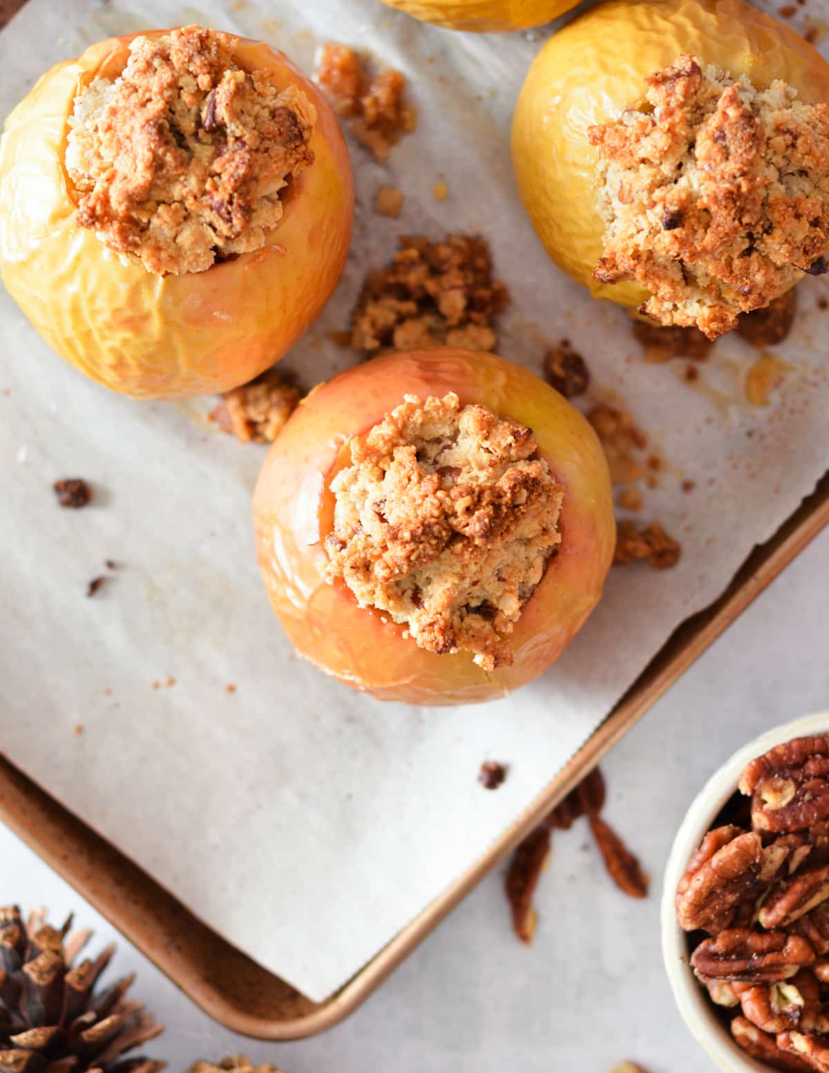 baked apples on a sheet pan stuffed with oat crumble.