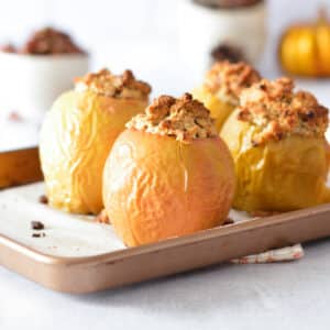 baked apples stuffed with crumble on a sheet pan.