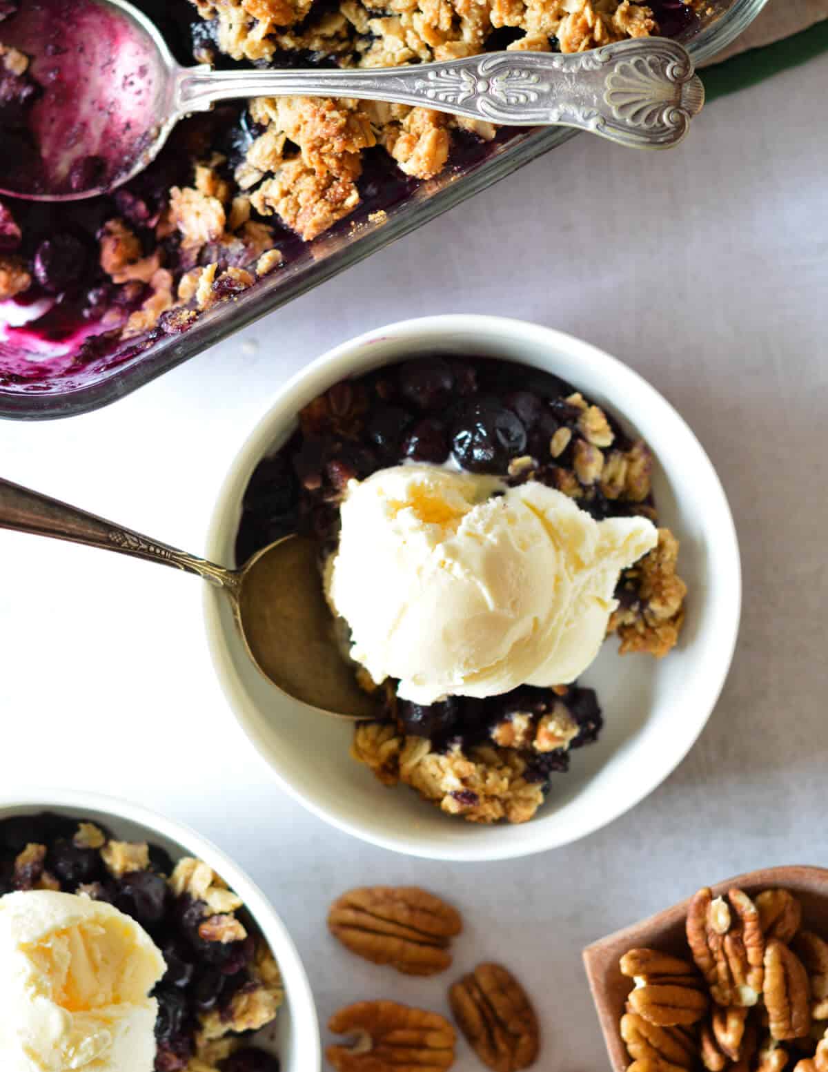 a bowl of blueberry crisp topped with ice cream.