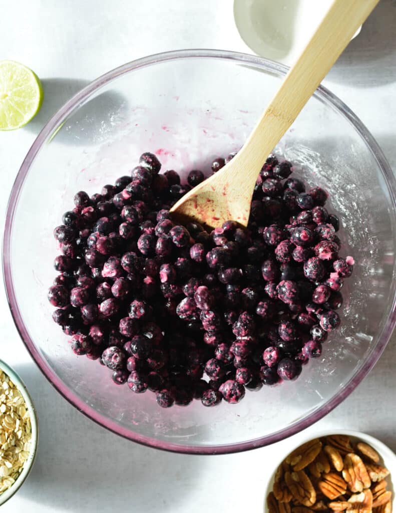 a bowl of frozen blueberries mixed with maple syrup