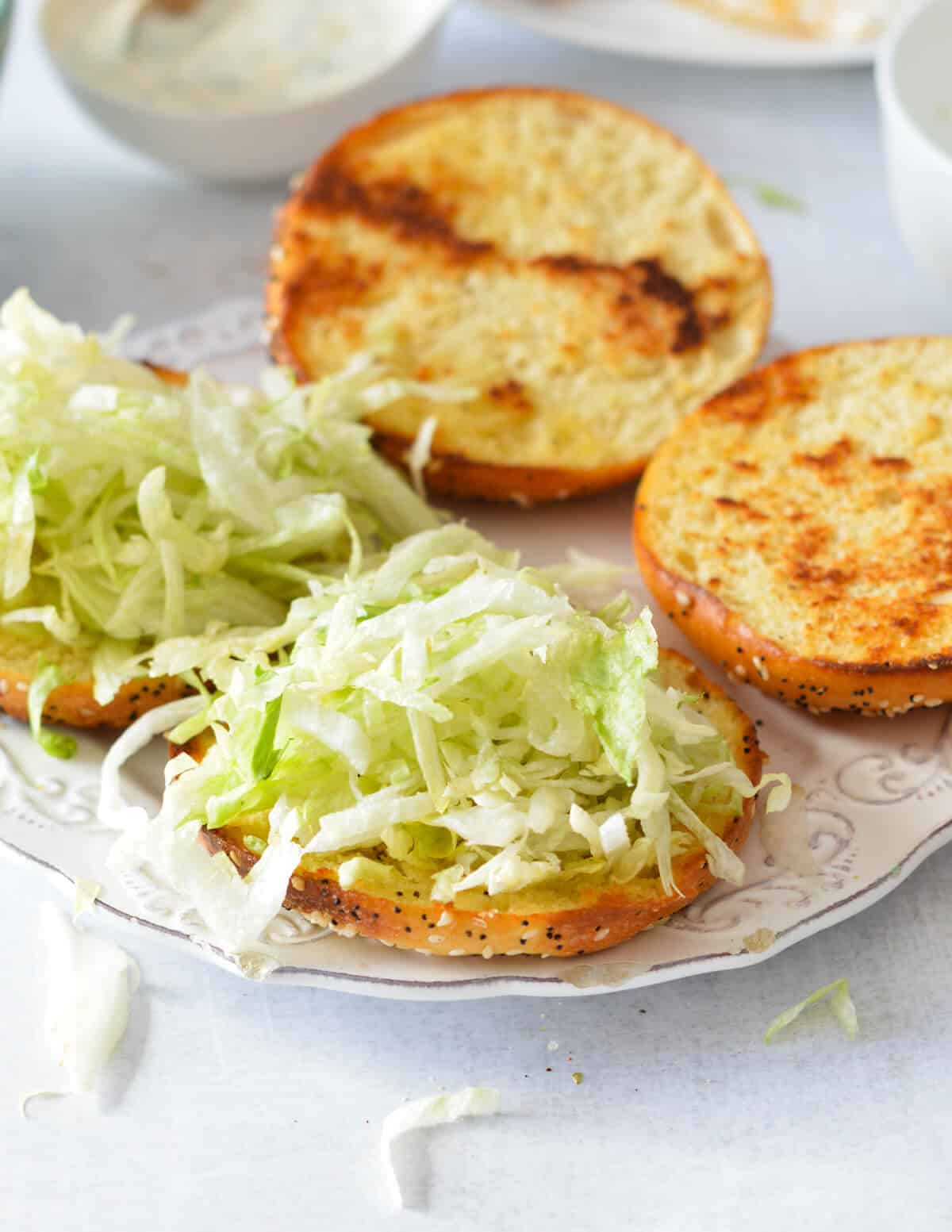 toasted buns with shredded lettuce on top.