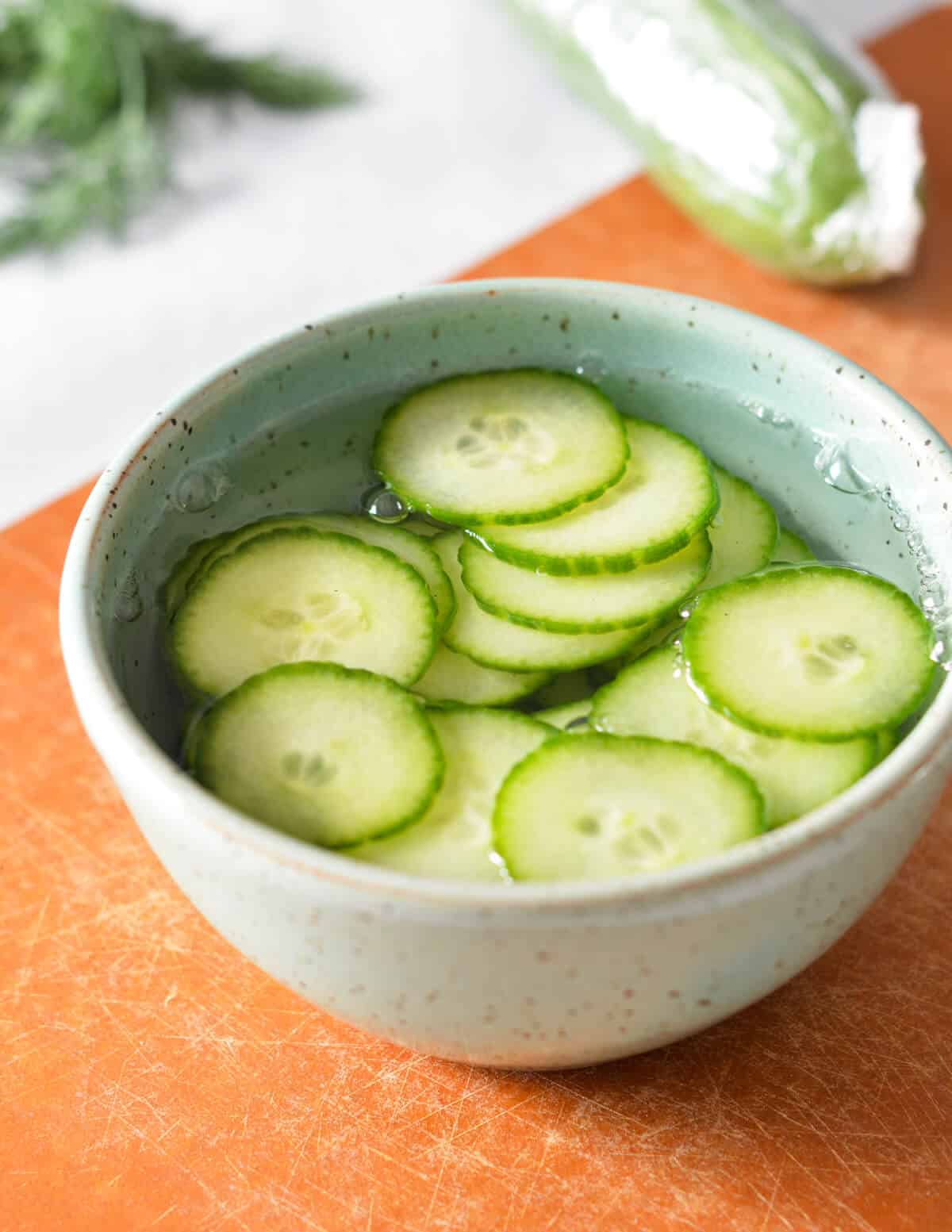 a bowl of cucumbers in water