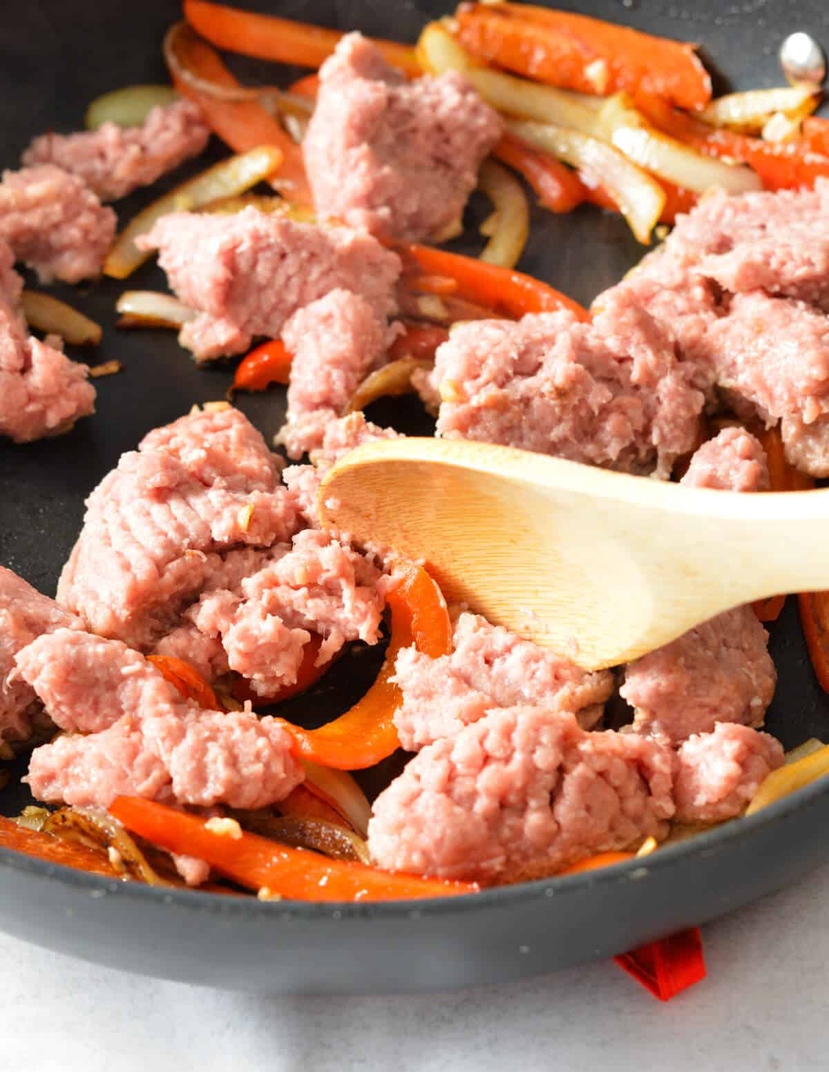 raw ground turkey with peppers in a skillet.