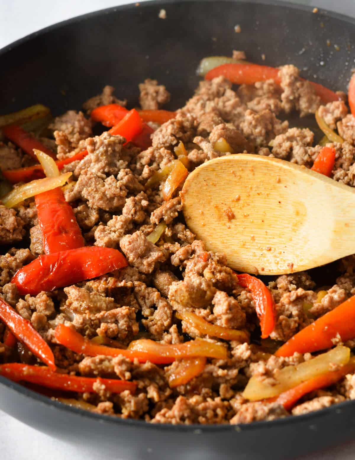 cooked ground turkey, peppers, and onions in a skillet.