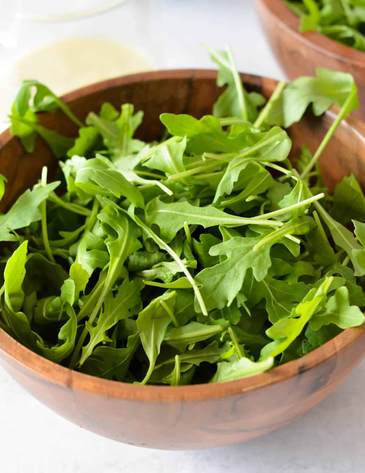 a bowl of baby arugula leaves. 