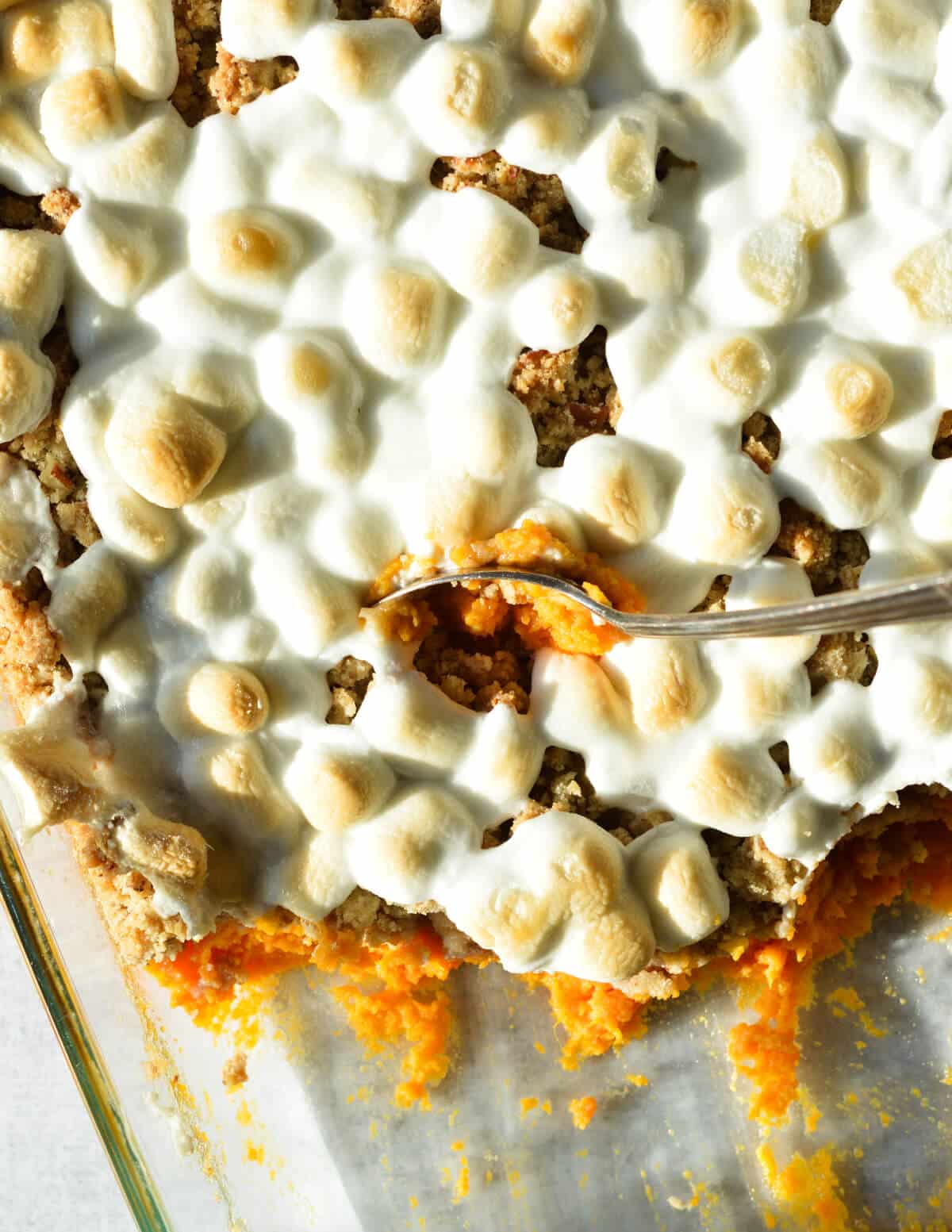 a spoonful of sweet potato casserole with toasted marshmallows on top.