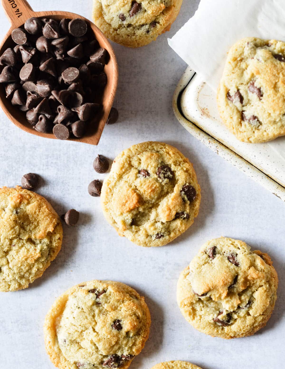 almond flour chocolate chip cookies near a cup of chocolate chips.