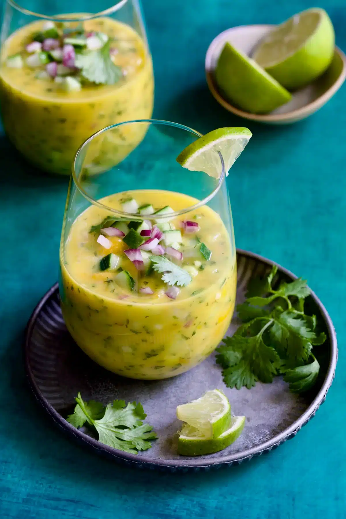 a glass of mango gazpacho with red onion and cucumber. 