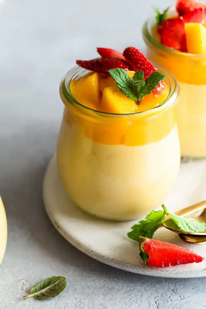 a jar of mango mousse with mango chunks on top. 