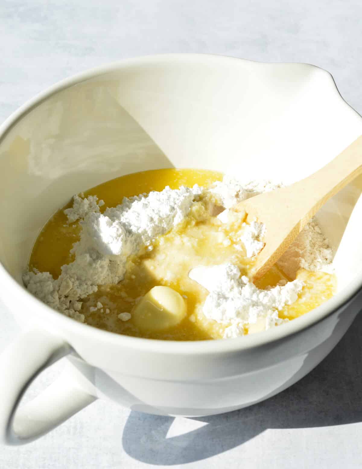 stirring flour, powdered sugar, and melted butter together in a bowl.