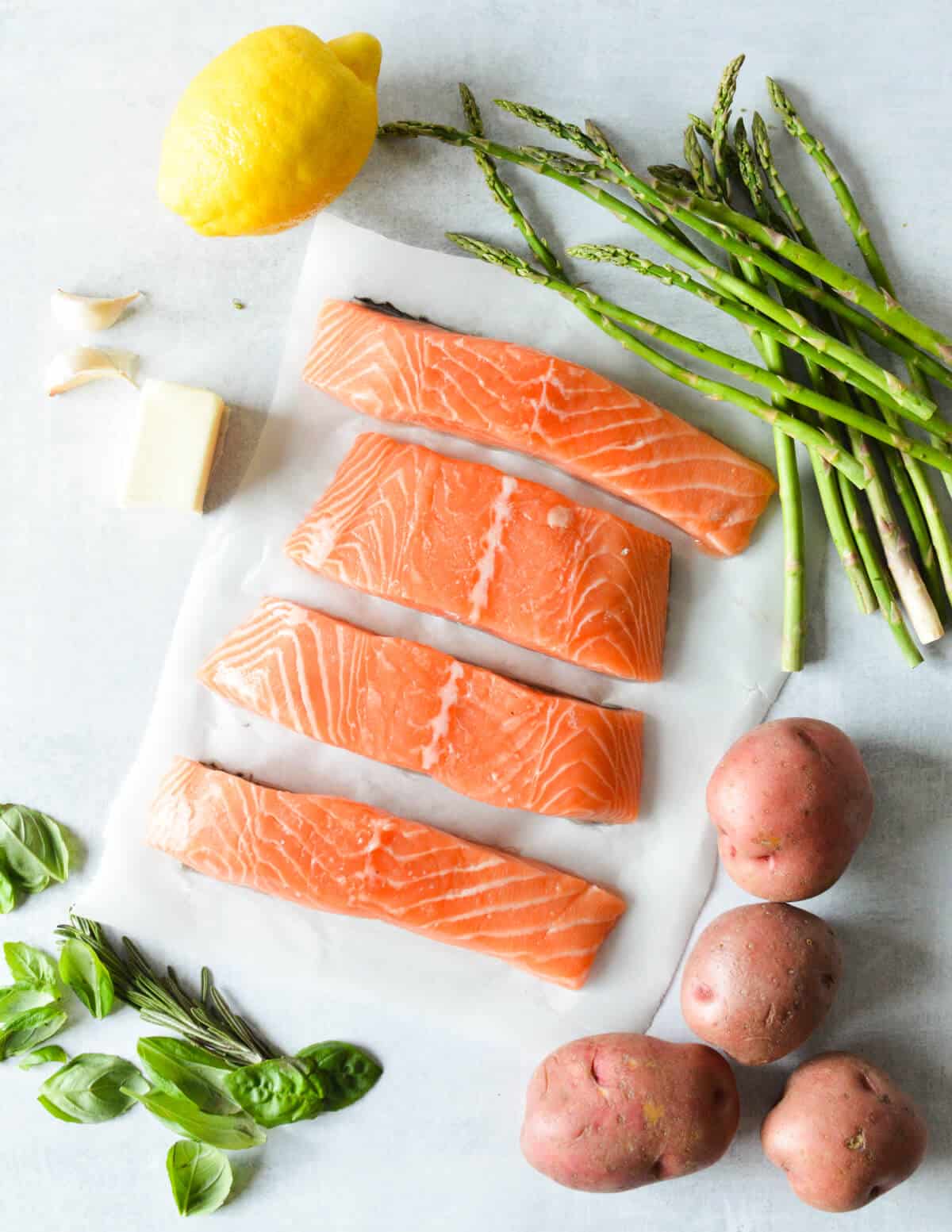 asparagus, salmon, lemon, butter, garlic, red potatoes, basil, rosemary.