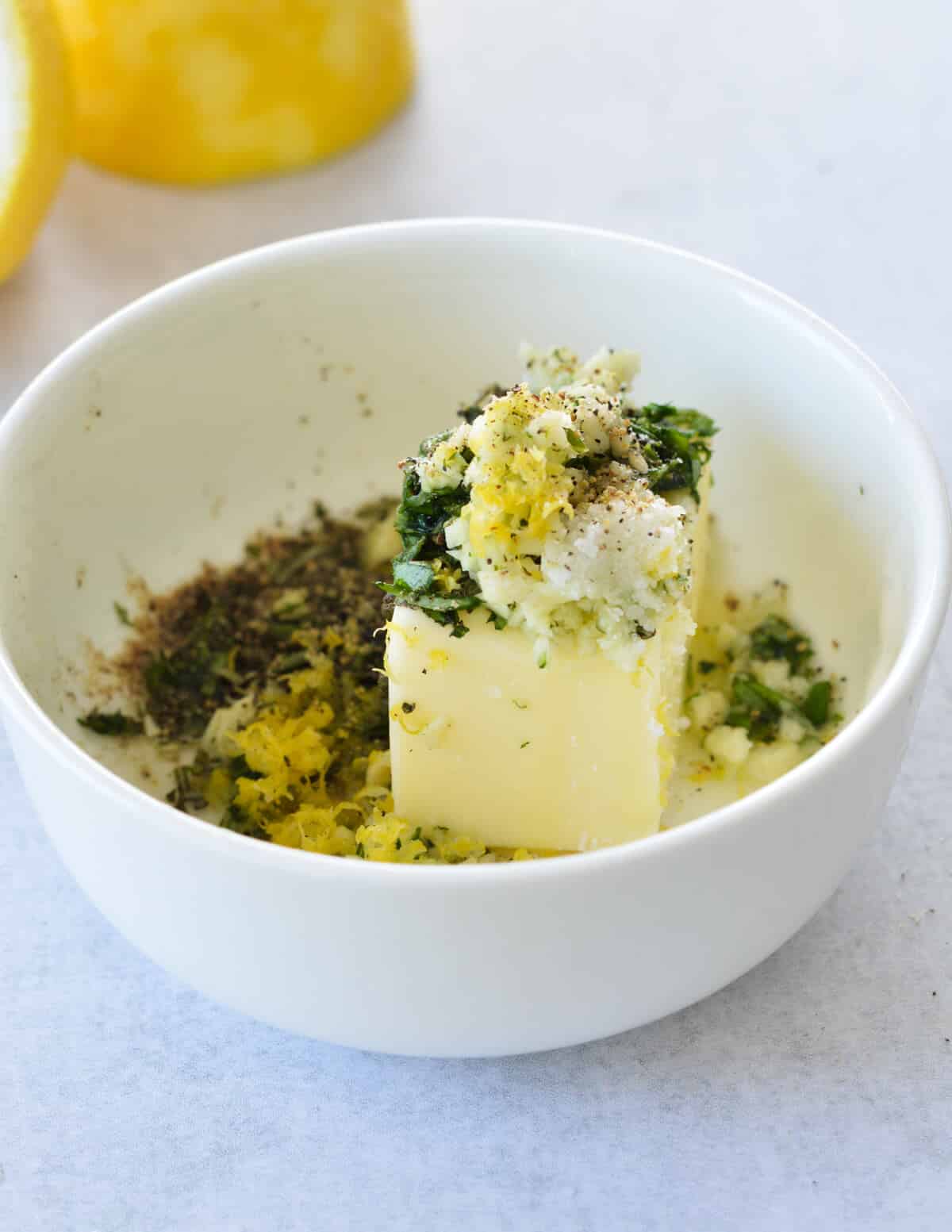 a bowl of softened butter with herbs and lemon zest. 