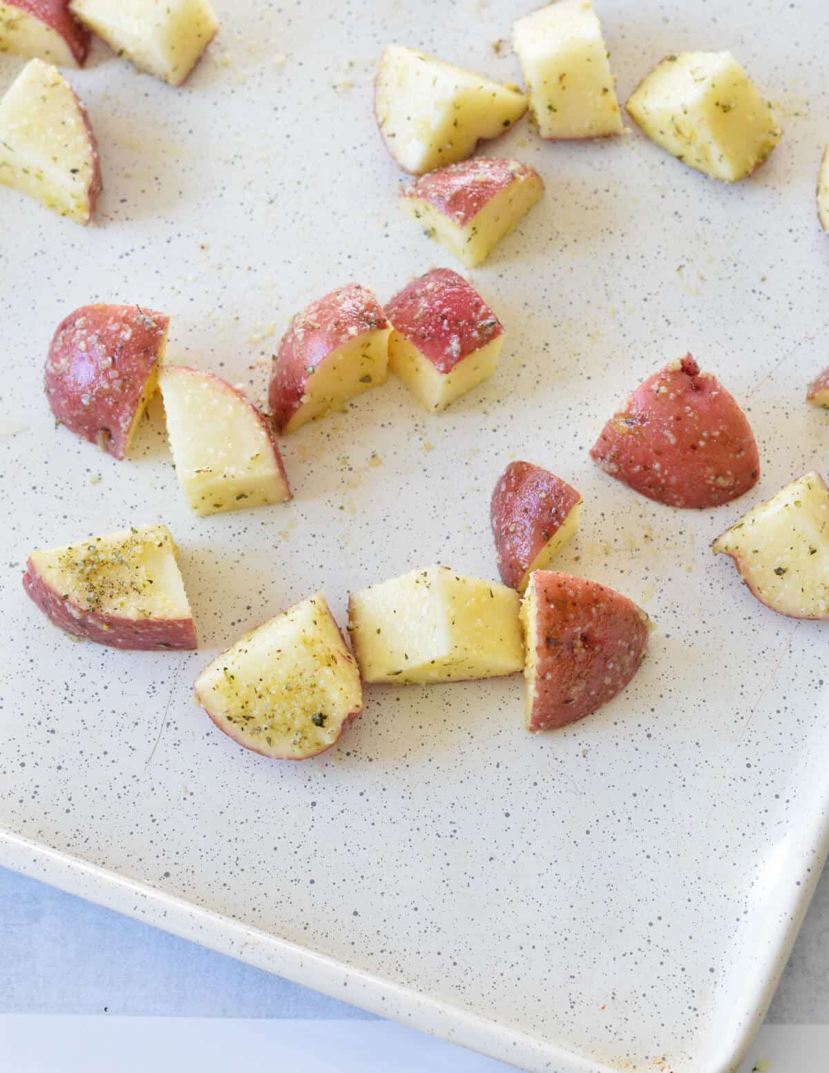 seasoned red potatoes on a sheet pan. 