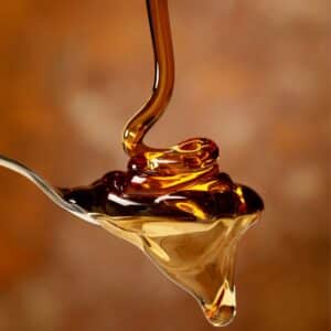 drizzling maple syrup onto a spoon.