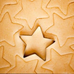 rolled out cookie dough with star shapes cut out of it.