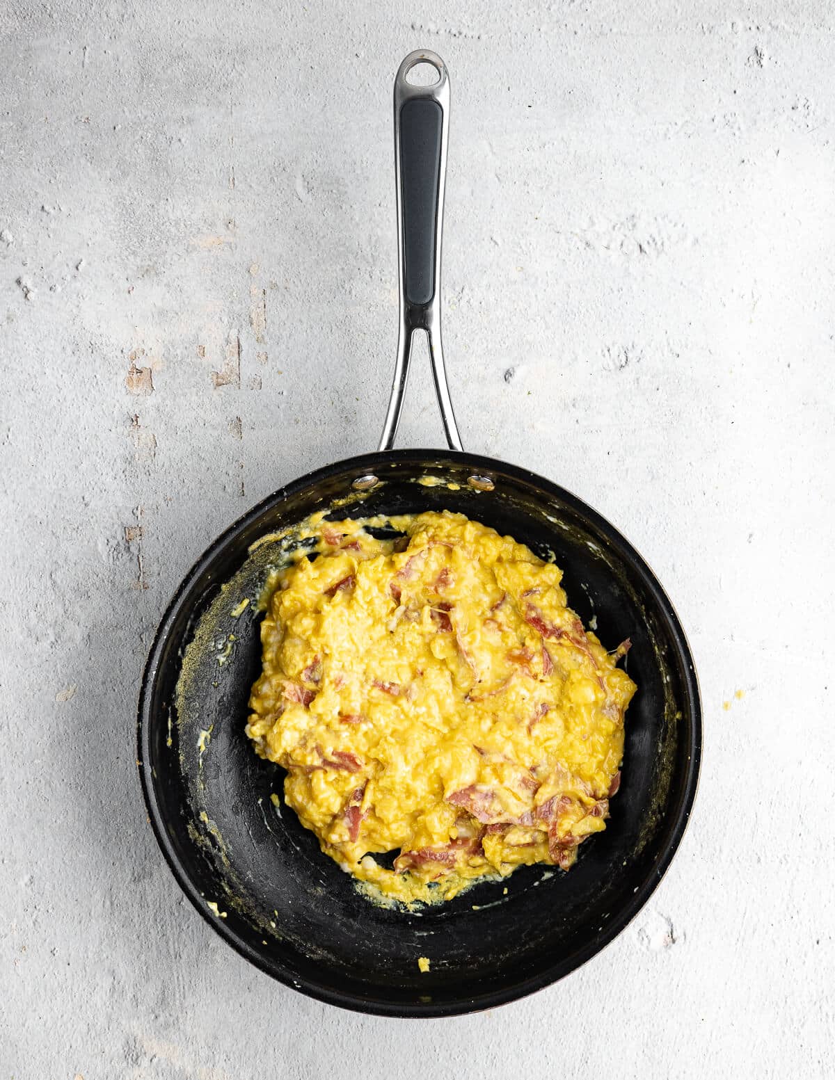 cheesy scrambled eggs in a skillet.