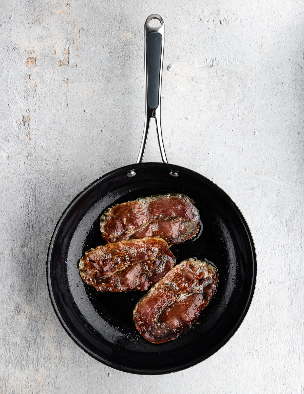 pan fried prosciutto in a skillet