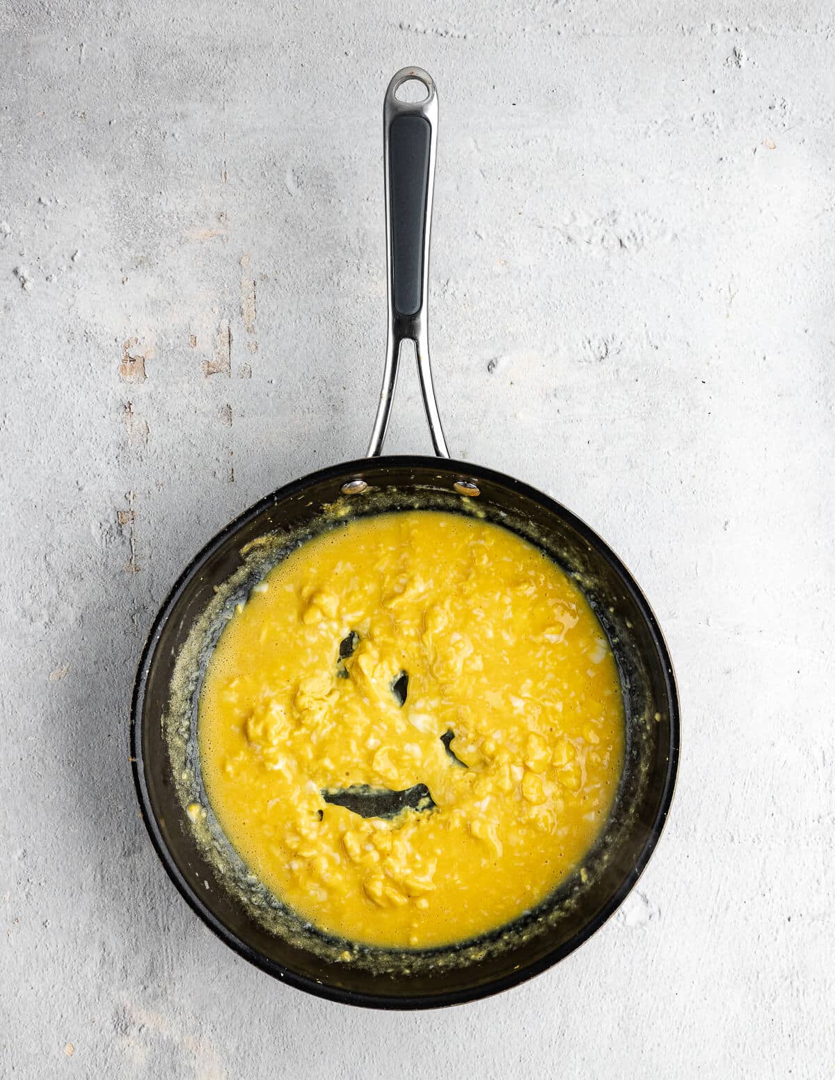partially cooked scrambled eggs in a skillet.