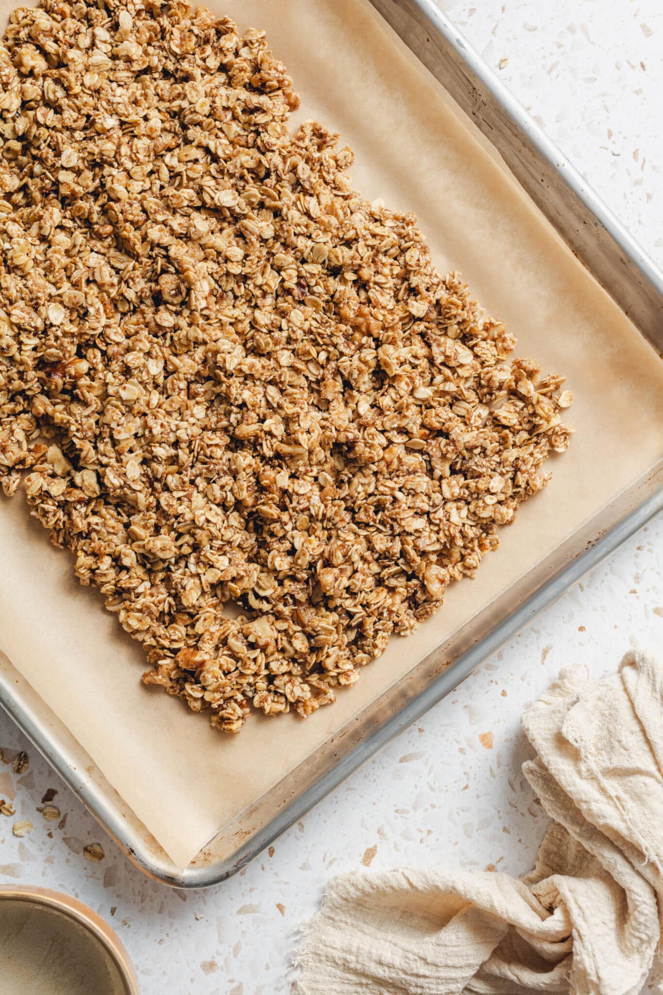 wet oat mixture on a sheet pan with parchment paper.