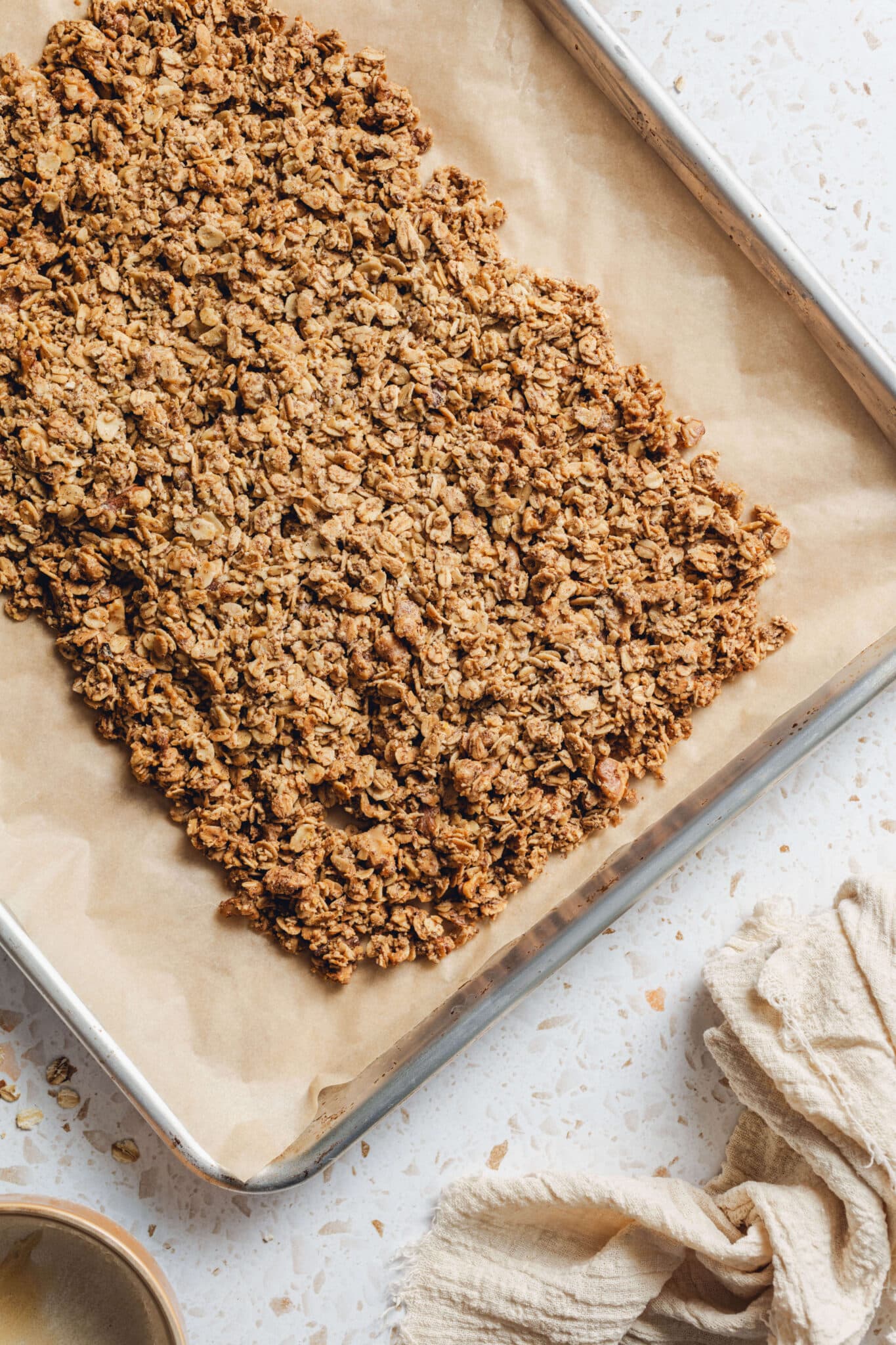baked oat mixture on a sheet pan with parchment paper.