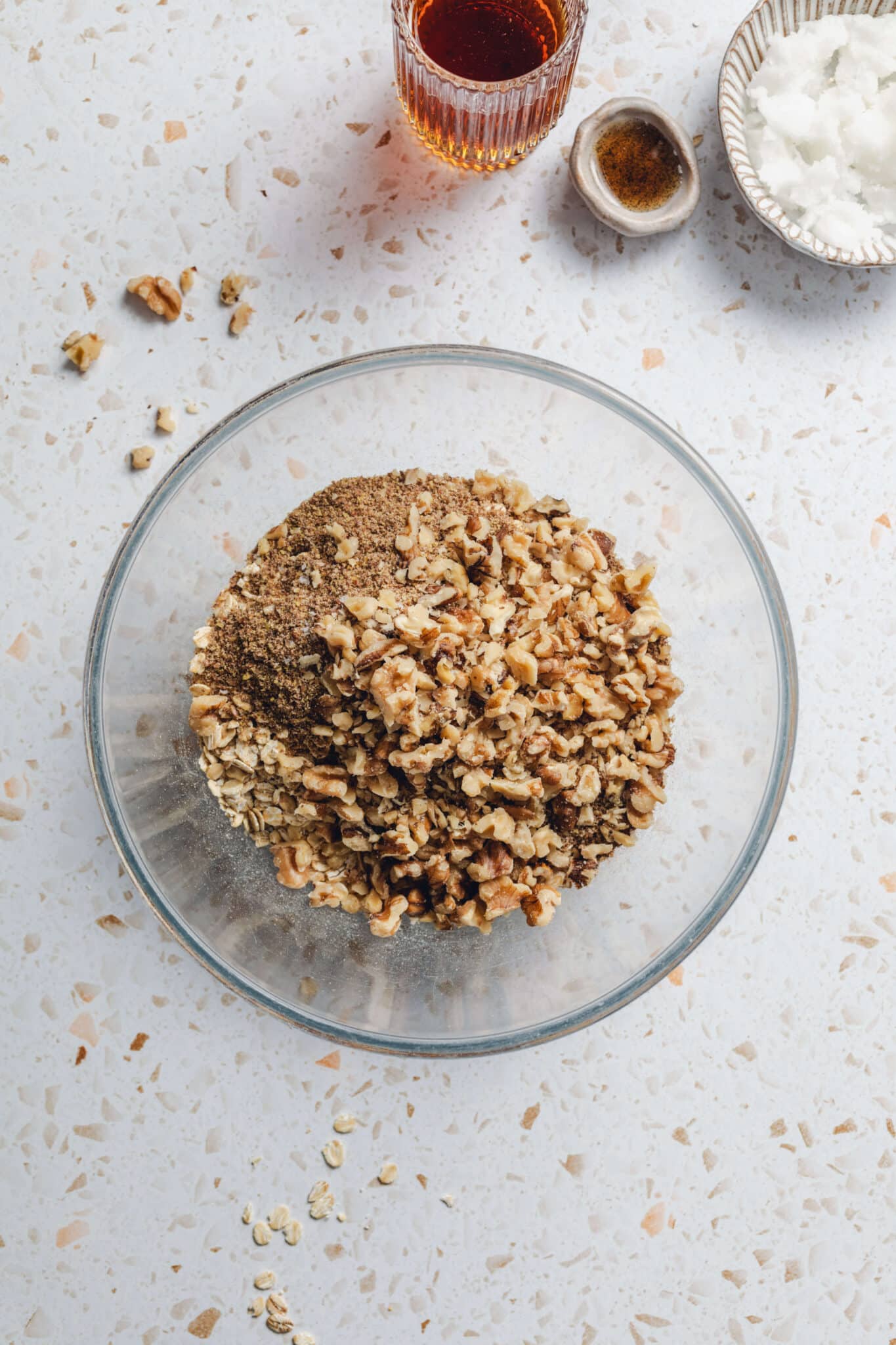 a bowl of walnuts, oats, flax meal, cinnamon, and salt.